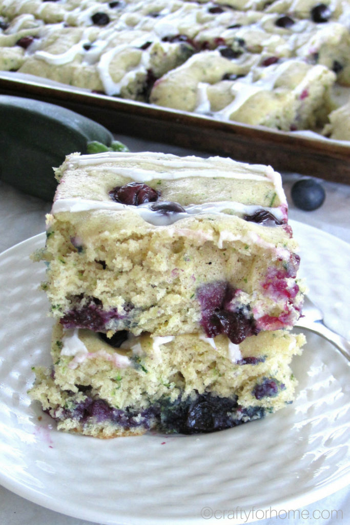 Easy dairy-free blueberry zucchini cake recipe with the lemon icing glaze. Bake it on the sheet pan to make cake bars. #dairyfree #sheetcake #zucchinicake #lemonicing for full recipe on craftyforhome.com