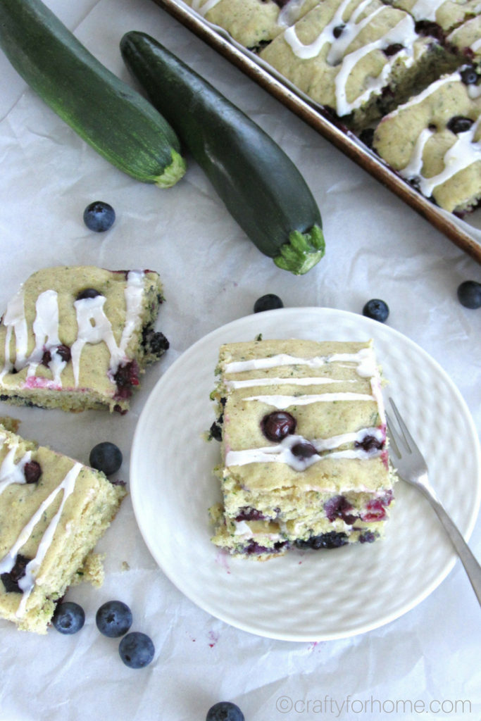 Easy dairy-free blueberry zucchini cake recipe with the lemon icing glaze. Bake it on the sheet pan to make cake bars. #dairyfree #sheetcake #zucchinicake #lemonicing for full recipe on craftyforhome.com