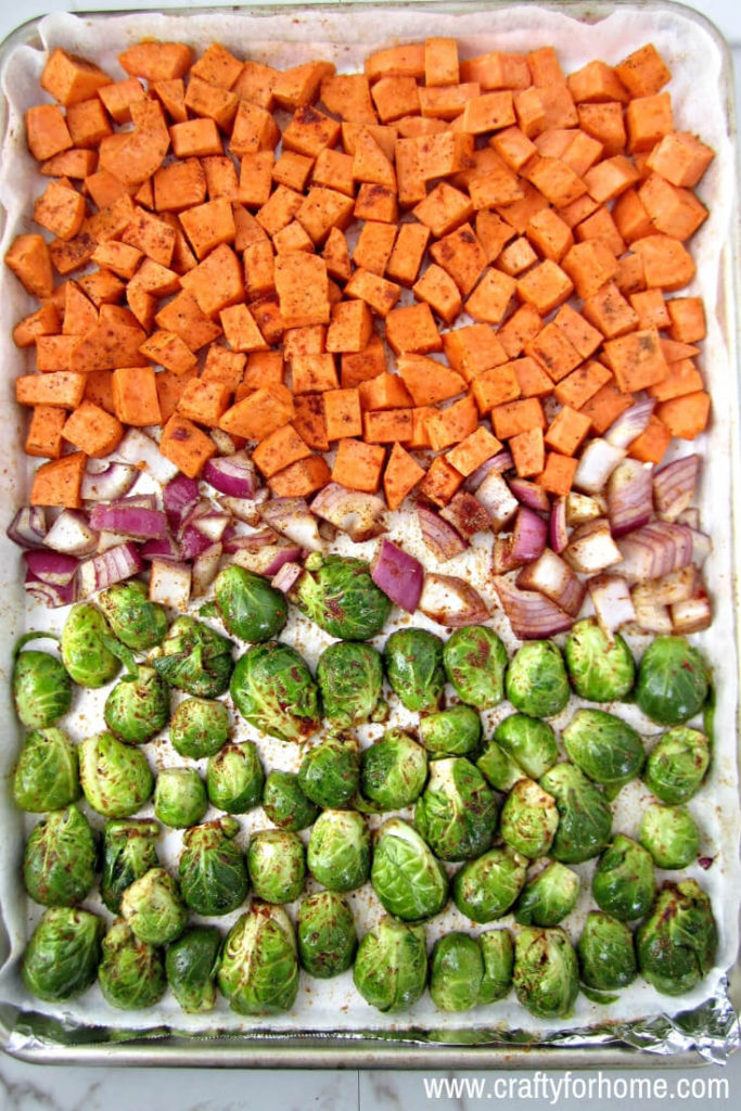 Cut up sweet potato, onion, and Brussel sprout on the pan