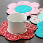 White cup with fabric flower shaped coaster