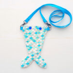 Mermaid tail bag for coin with blue strap.