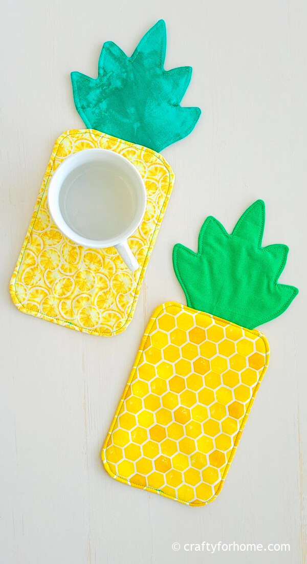 Two pineapple shape fabric coasters.
