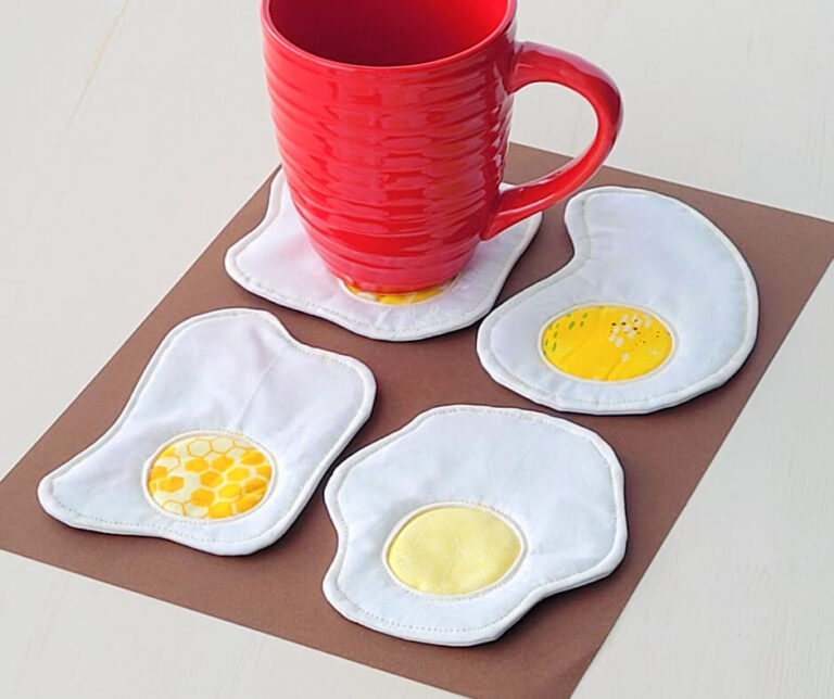 Red mug with four sunny side up egg coasters.