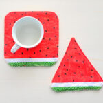 Square watermelon mug rug with white mug.