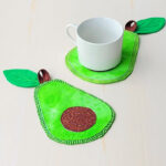 Avocado coaster from fabric with white mug.