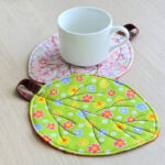 White Mug On Quilted Leaf Coaster.