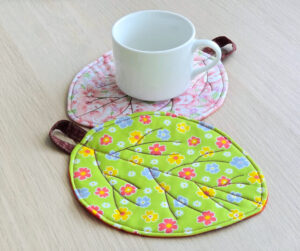 White Mug On Quilted Leaf Coaster.